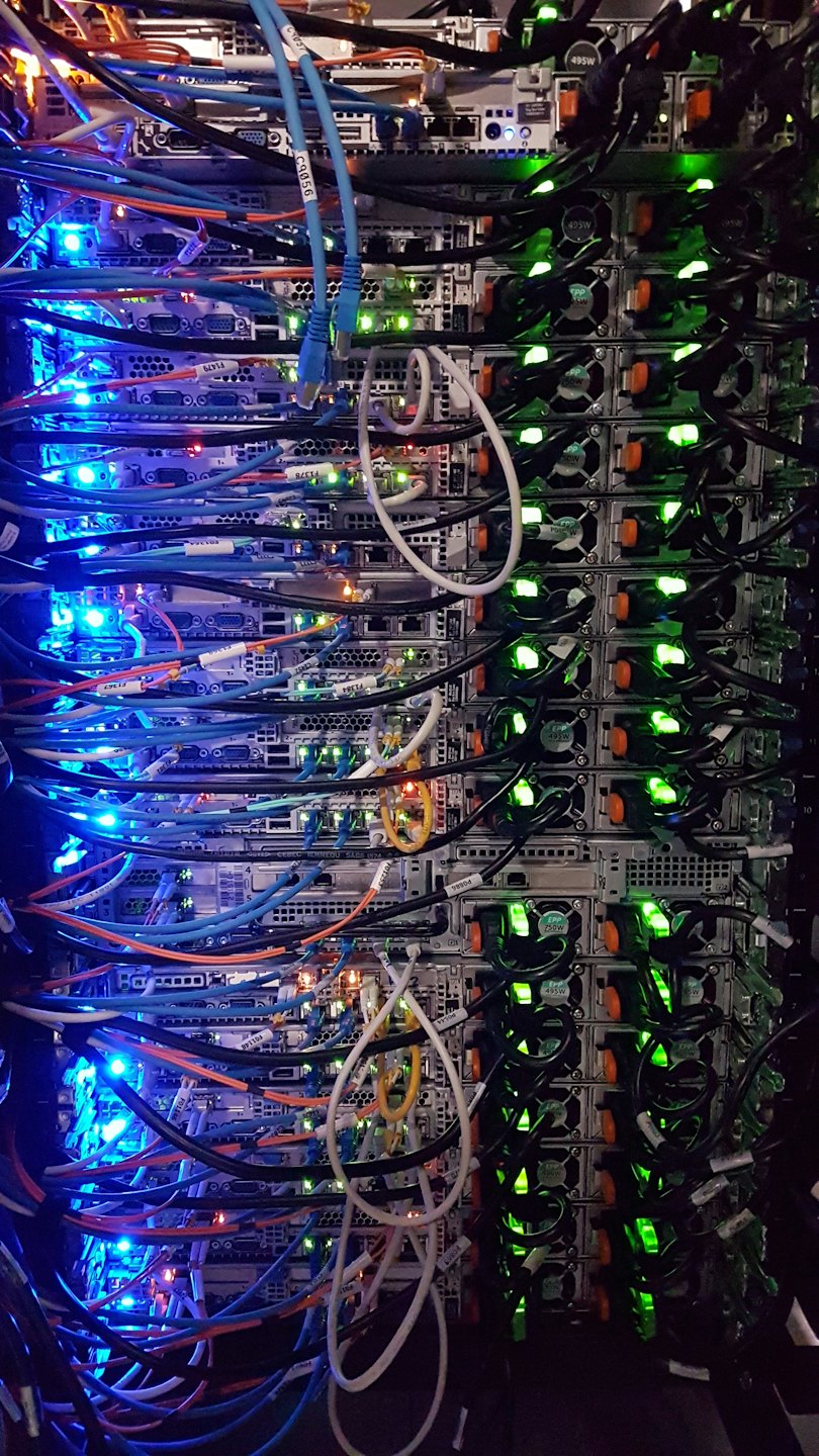 Server rack with many colorful cables and glowing lights.